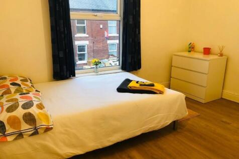 A cozy single bedroom featuring a neatly made b...
