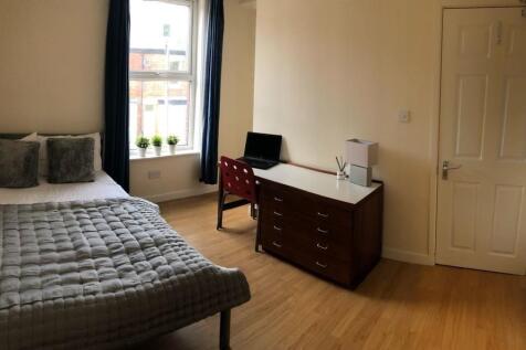 A cozy and tidy single bedroom featuring a comf...