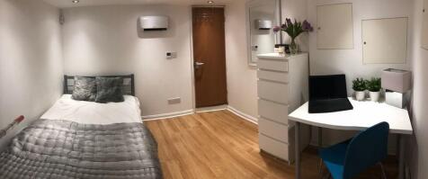A cozy and well-organized single bedroom featur...