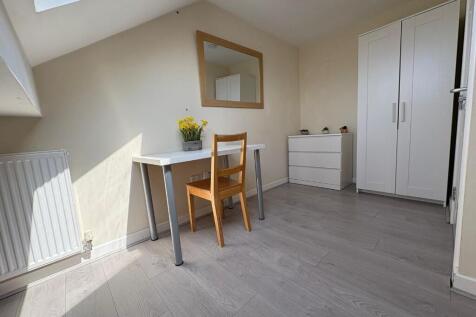 A bright and clean single bedroom featuring a l...