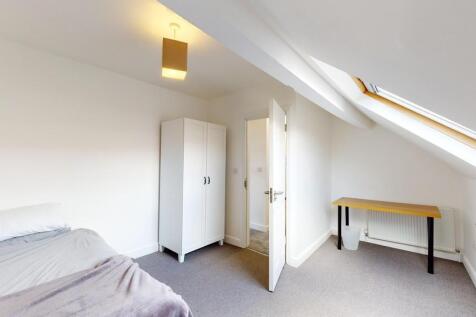 A spacious and bright master bedroom featuring ...