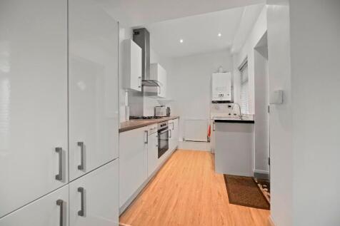 A modern, sleek kitchen with clean white cabine...