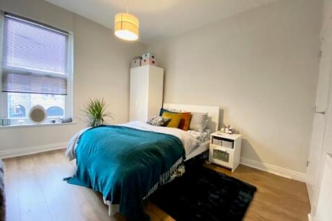 A bright and inviting double bedroom with a com...