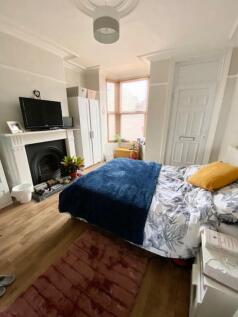 A cozy double bedroom with a comfortable bed dr...