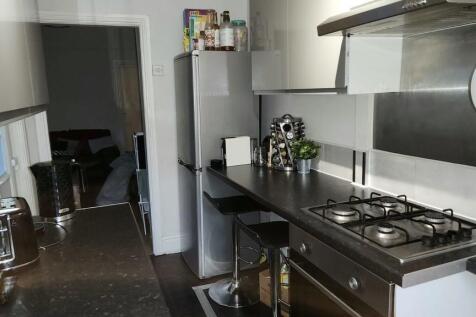 A modern kitchen featuring sleek black countert...