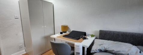 A neat and functional single bedroom featuring ...