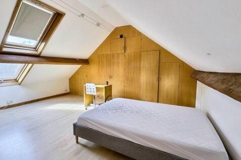 Spacious attic master bedroom featuring large s...