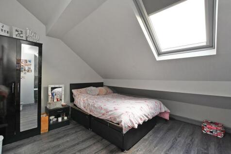 Bright and cozy attic bedroom featuring a skyli...
