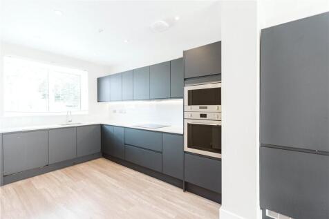 Bright and modern kitchen with sleek dark cabin...