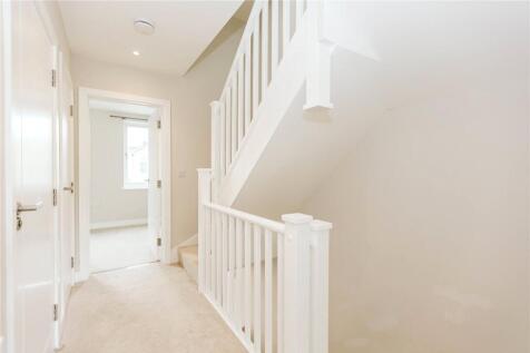 Bright and clean hallway with white walls and c...