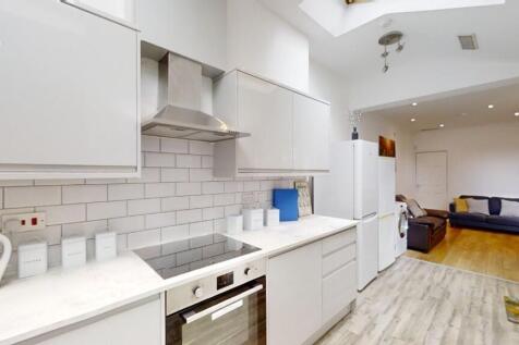 A modern, clean kitchen featuring white cabinet...