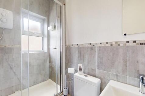 A modern bathroom featuring a walk-in glass sho...