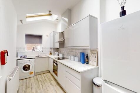 Bright and modern kitchen featuring ample white...
