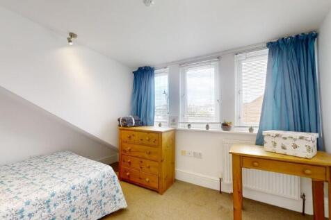 Bright and cozy single bedroom featuring a comf...
