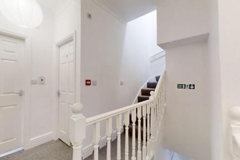 Bright and clean hallway featuring a white bani...