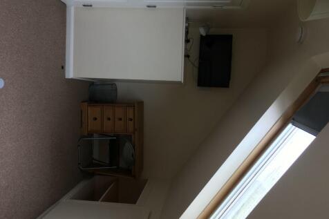 A cozy single bedroom featuring a large window ...