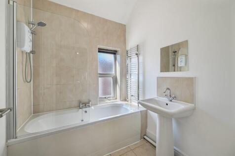Bright and clean bathroom suite featuring a lar...