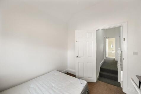 A bright and clean single bedroom featuring a s...
