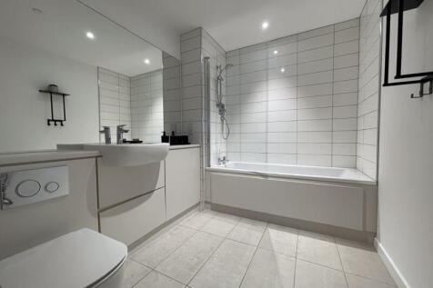 A modern and pristine bathroom suite featuring ...