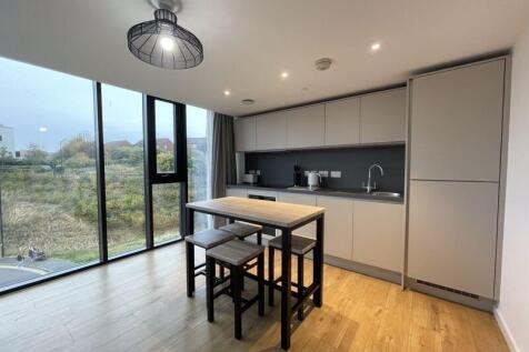 Modern kitchen area featuring sleek cabinetry, ...