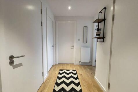 A bright and clean hallway featuring light wood...