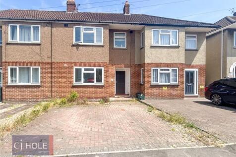 A well-maintained terraced house with a paved d...