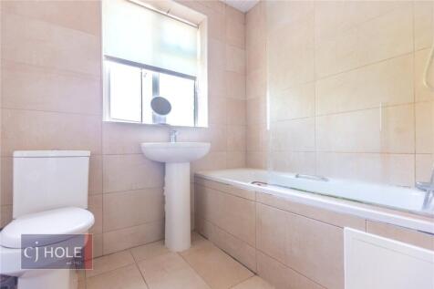 Bright and clean bathroom suite featuring a lar...
