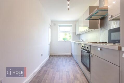A bright and modern kitchen featuring sleek cab...