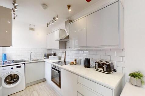 Bright and modern kitchen featuring sleek white...