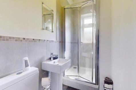 Bright and clean bathroom suite featuring a mod...