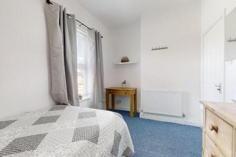 A bright and tidy single bedroom featuring a co...