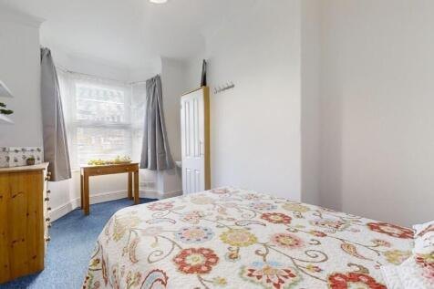 Bright single bedroom featuring a large window ...