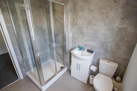 A modern bathroom featuring a glass-enclosed sh...