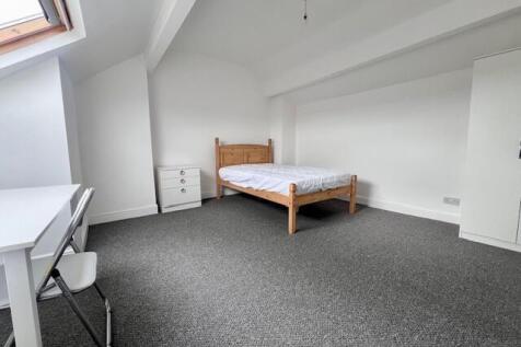 A spacious and bright master bedroom featuring ...