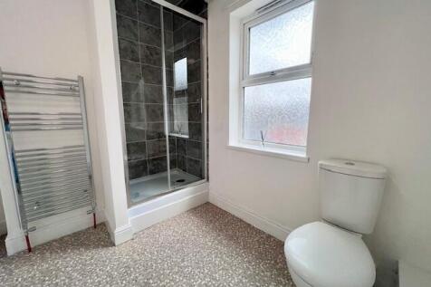 A clean, modern bathroom featuring a walk-in sh...