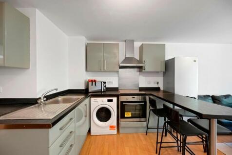 A modern and tidy kitchen featuring light-color...