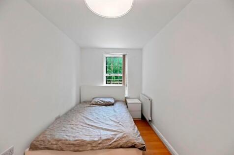 A cozy single bedroom featuring a neatly made b...