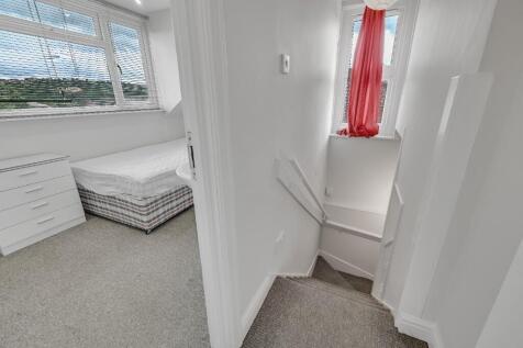 A bright and clean hallway leading to a small t...