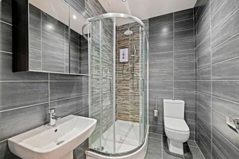 Modern bathroom suite featuring a sleek glass-e...