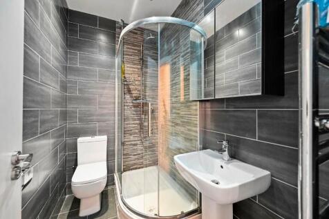Modern bathroom featuring a sleek curved glass ...