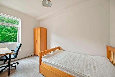 A bright and clean single bedroom featuring a w...