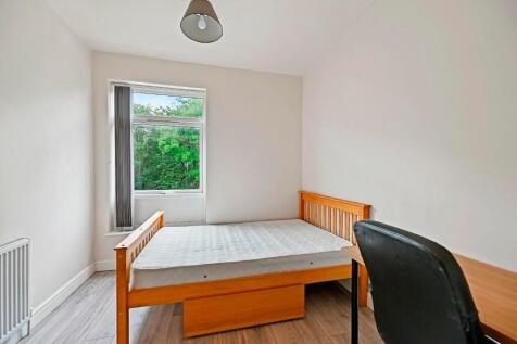 Bright and simple bedroom featuring a wooden be...