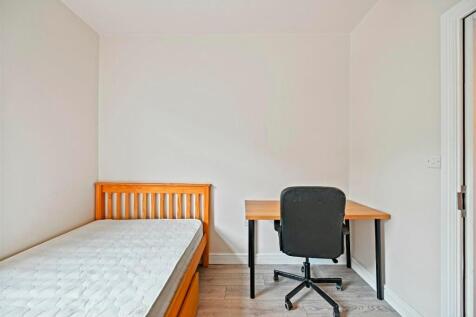 A neat and simple single bedroom featuring a wo...