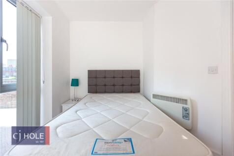 A bright, clean single bedroom featuring a larg...