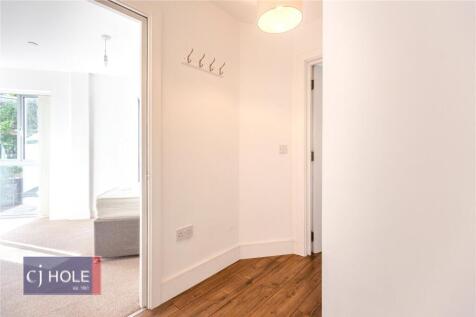 A clean and bright hallway with wooden flooring...