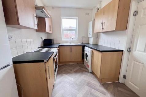 Bright and clean kitchen with modern wooden cab...