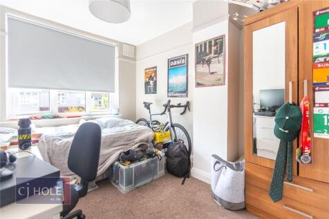 A bright and cozy single bedroom featuring a co...