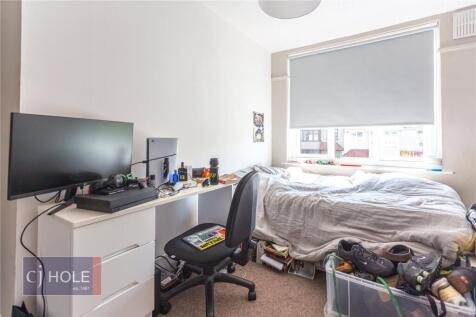 Cozy single bedroom featuring a comfortable bed...