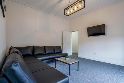 A modern living room featuring a large black le...