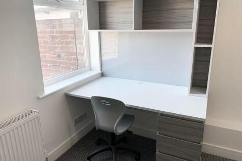 Bright and tidy workspace with a large desk, er...